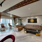 A luxurious 3BHK residence with Parisian-inspired interiors, featuring ornate moldings, a chandelier, velvet seating, and gold-accented decor.
