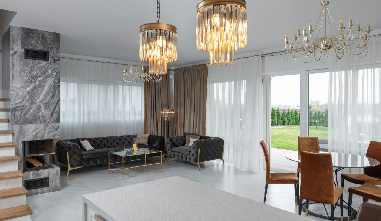 Modern 3 BHK luxury apartment interior with velvet sofa, chandelier, marble coffee table, and neutral-toned walls in Mumbai.