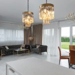Modern 3 BHK luxury apartment interior with velvet sofa, chandelier, marble coffee table, and neutral-toned walls in Mumbai.