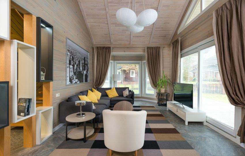 Luxurious living room interior with beige sofas, modern lighting, and marble walls in a 4BHK Mumbai flat.